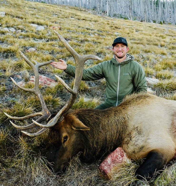Jake H. with a harvested bull elk on an Idaho mountainside